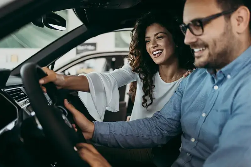 2 Personen sitzen in ihrem per Autokredit finanzierten PKW.