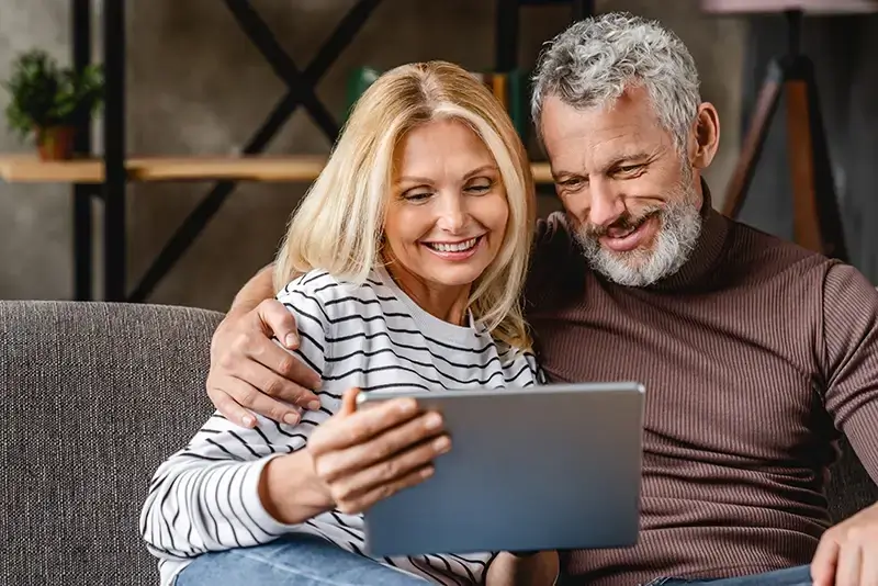 Ein Paar prüft auf dem Tablet verschiedene Privatkredite.